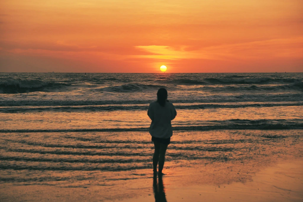 Woman silhouette against golden sunset on Vietnam beach